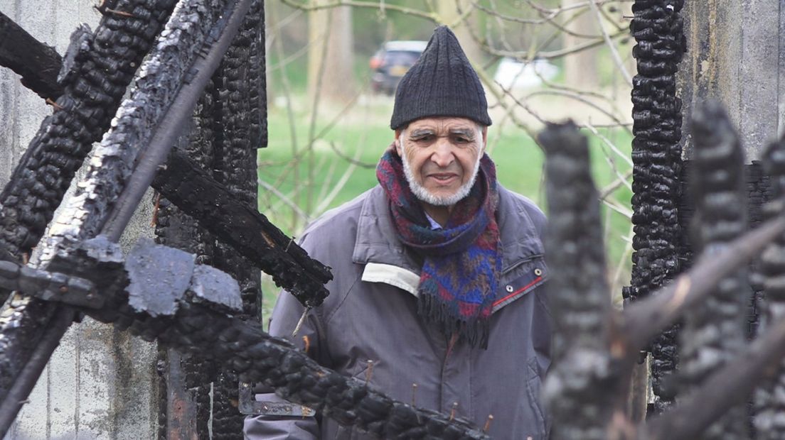 Driss Boudroz bekijkt de zwartgeblakerde resten van zijn tuinhuisje