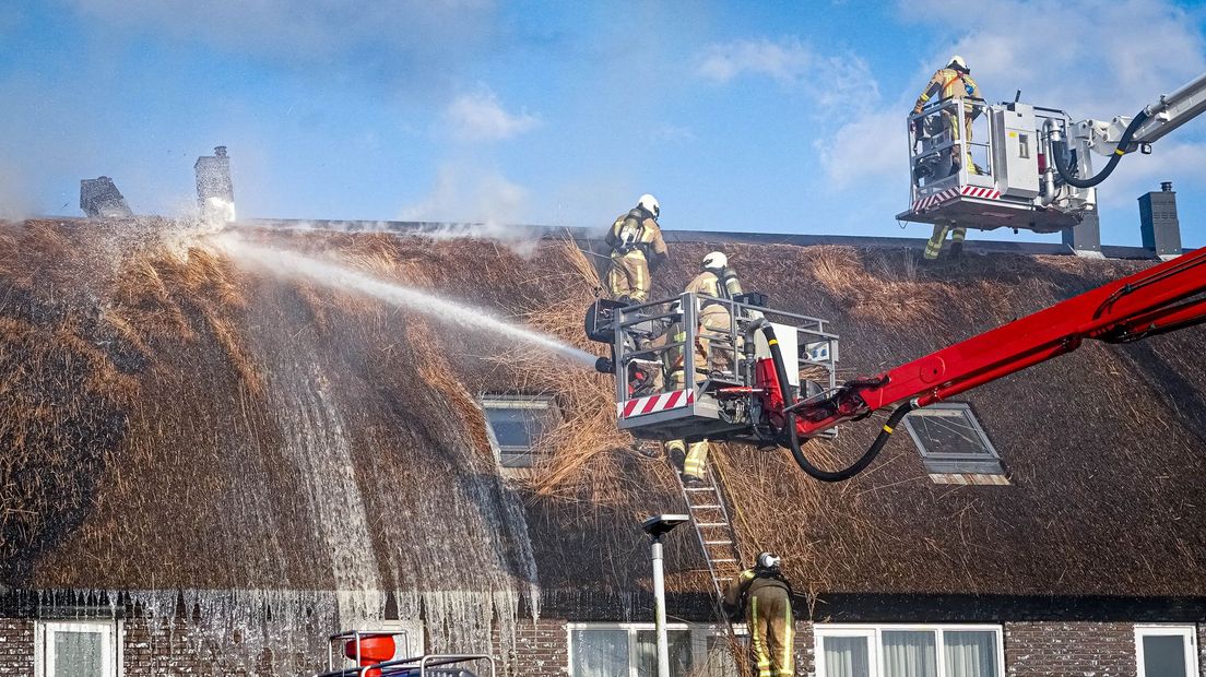 De brandweer bij het rieten dak