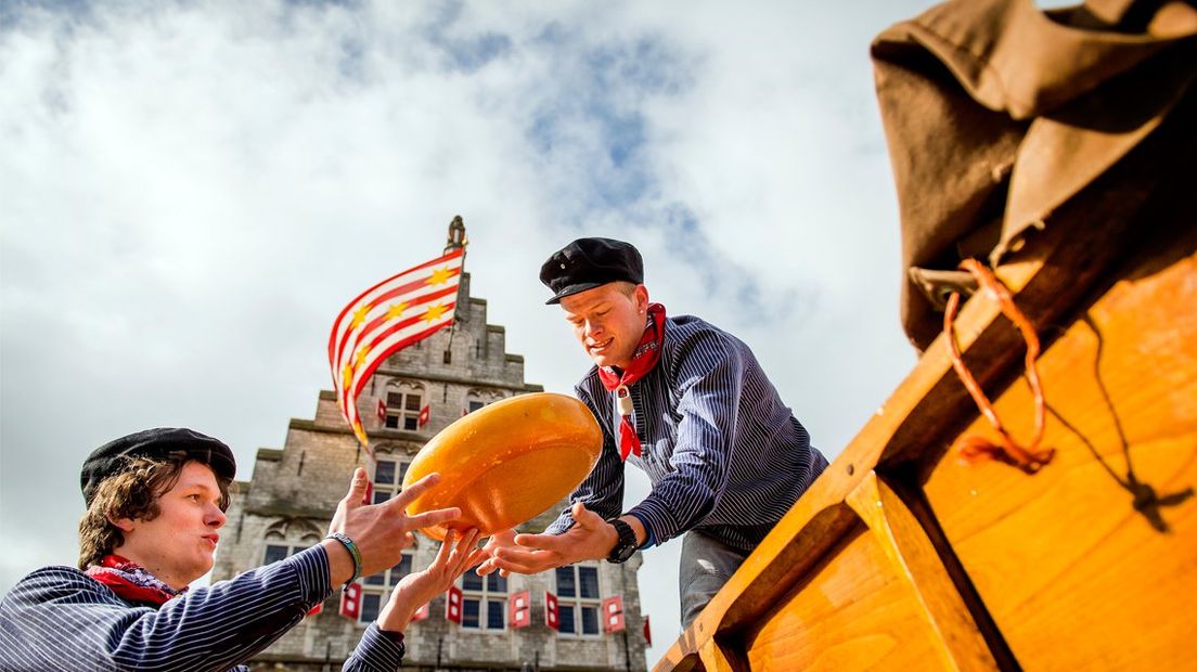 Kaasboeren in traditionele kleding halen de kaas binnen