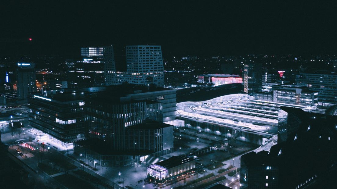 Het Utrechtse stationsgebied in de nacht met zichtbare verlichting.