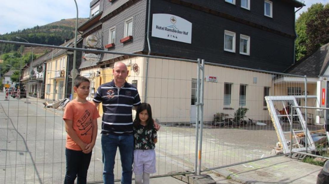 Willem Bult met zijn twee kinderen voor het afgezette terrein rondom het hotel