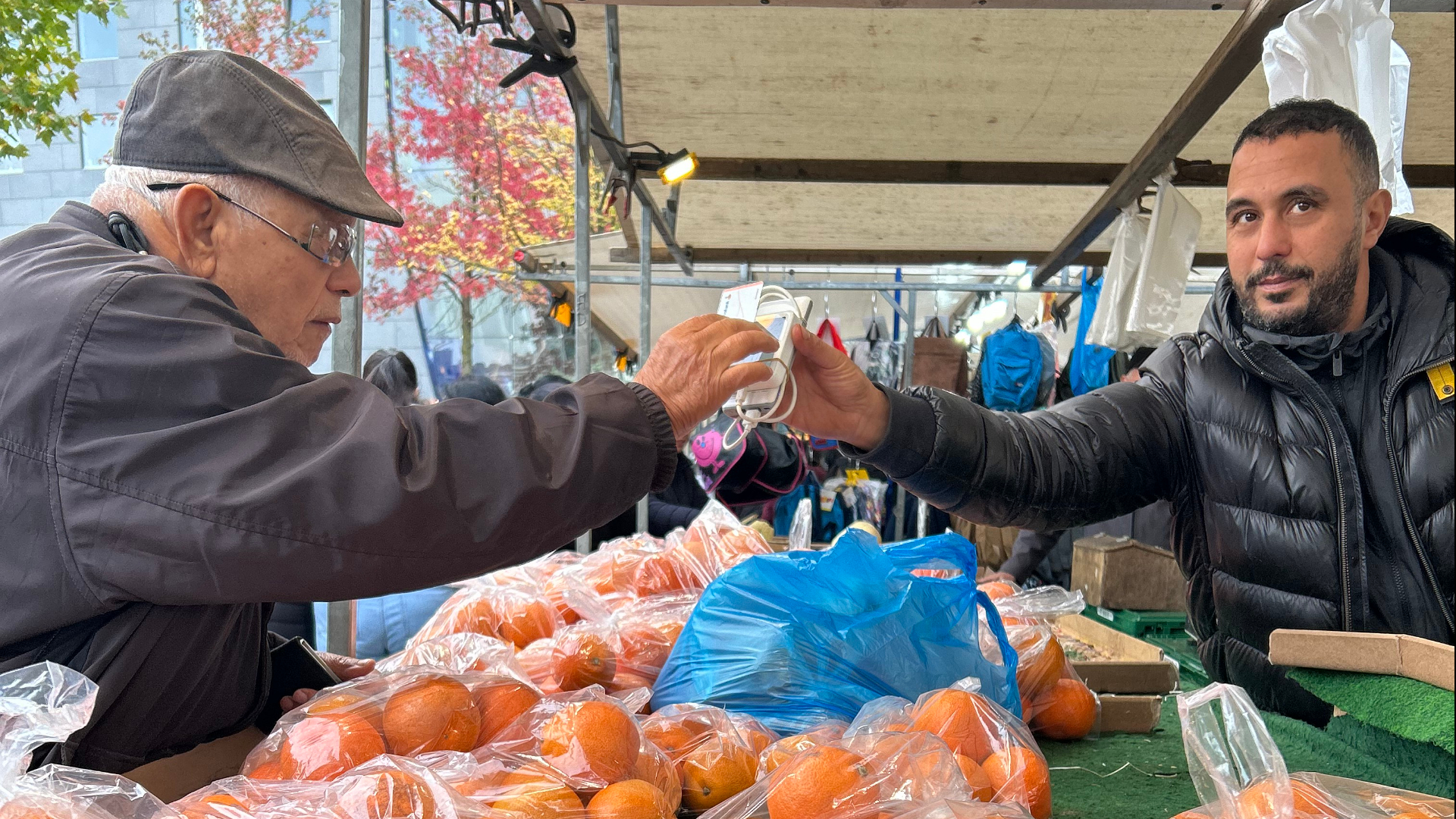 Marktkoopman Ali verkoopt aan het einde van de dag een van zijn laatste, afgeprijsde sinaasappelen
