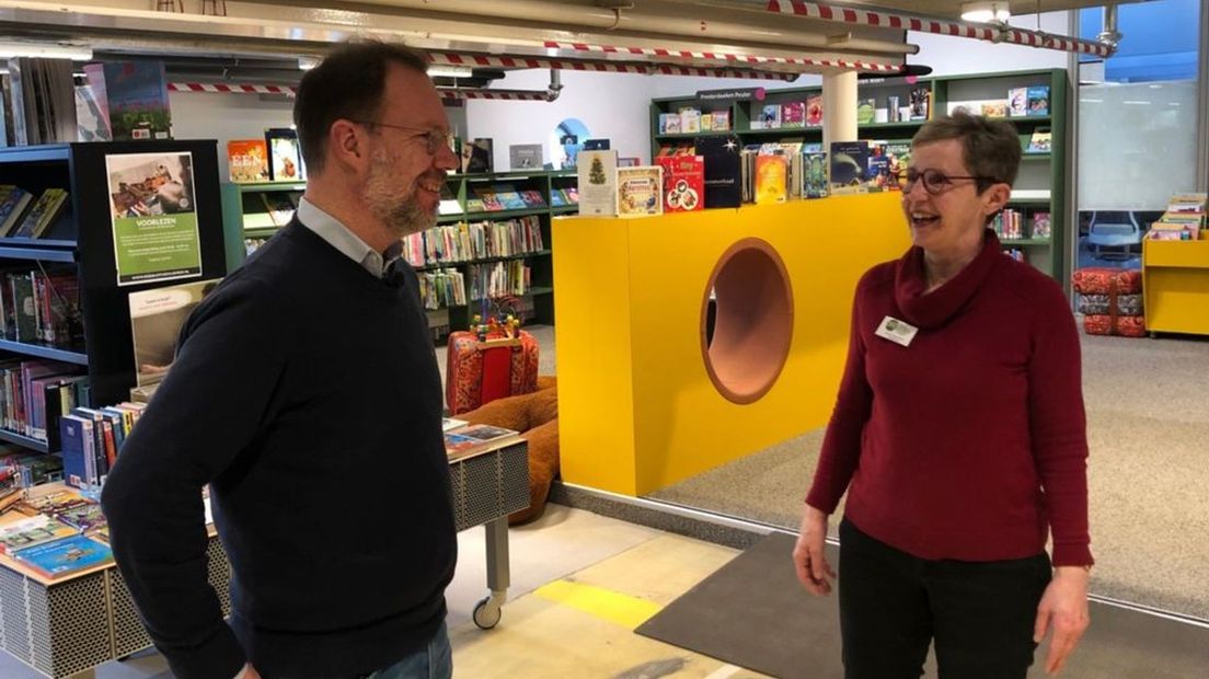 Bert Frölich in gesprek met een bibliotheek-medewerker
