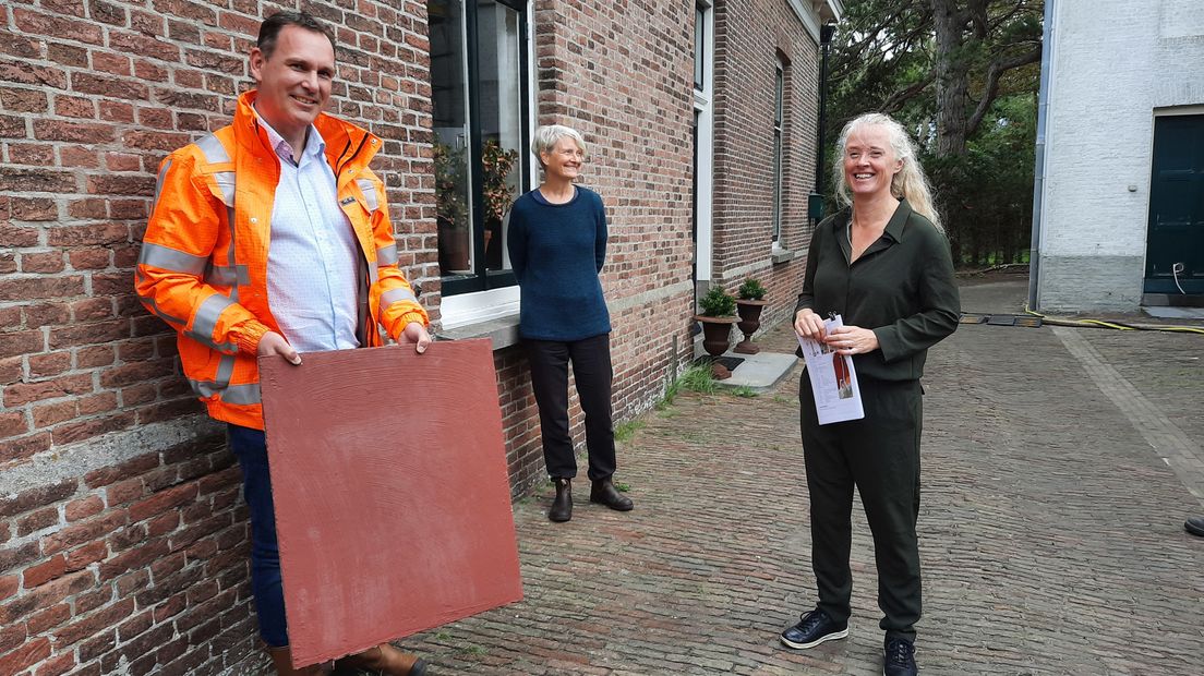 Medewerker Rijkswaterstaat met de nieuwe rode kleur voor de vuurtoren.