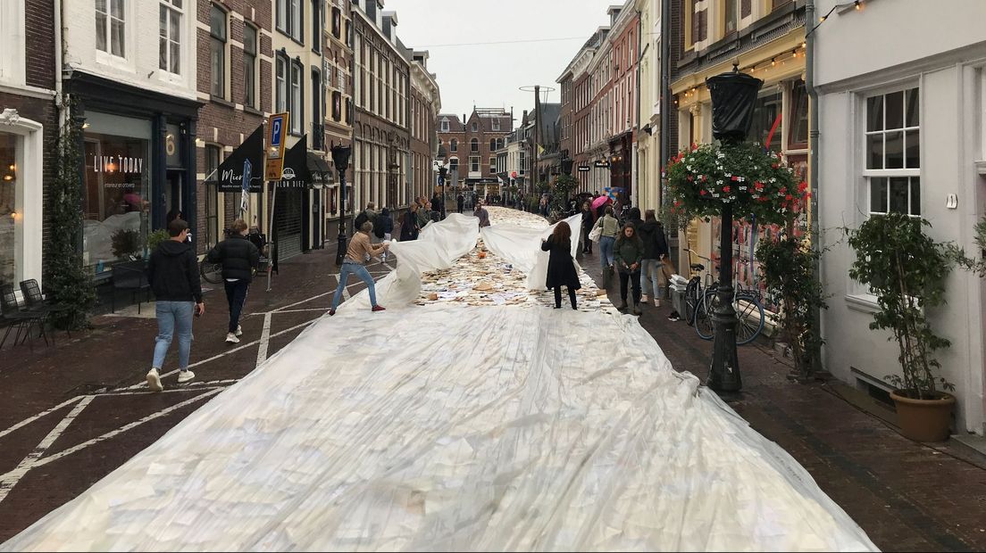 Vanwege de aankomende regen leggen mensen plastic over de boeken