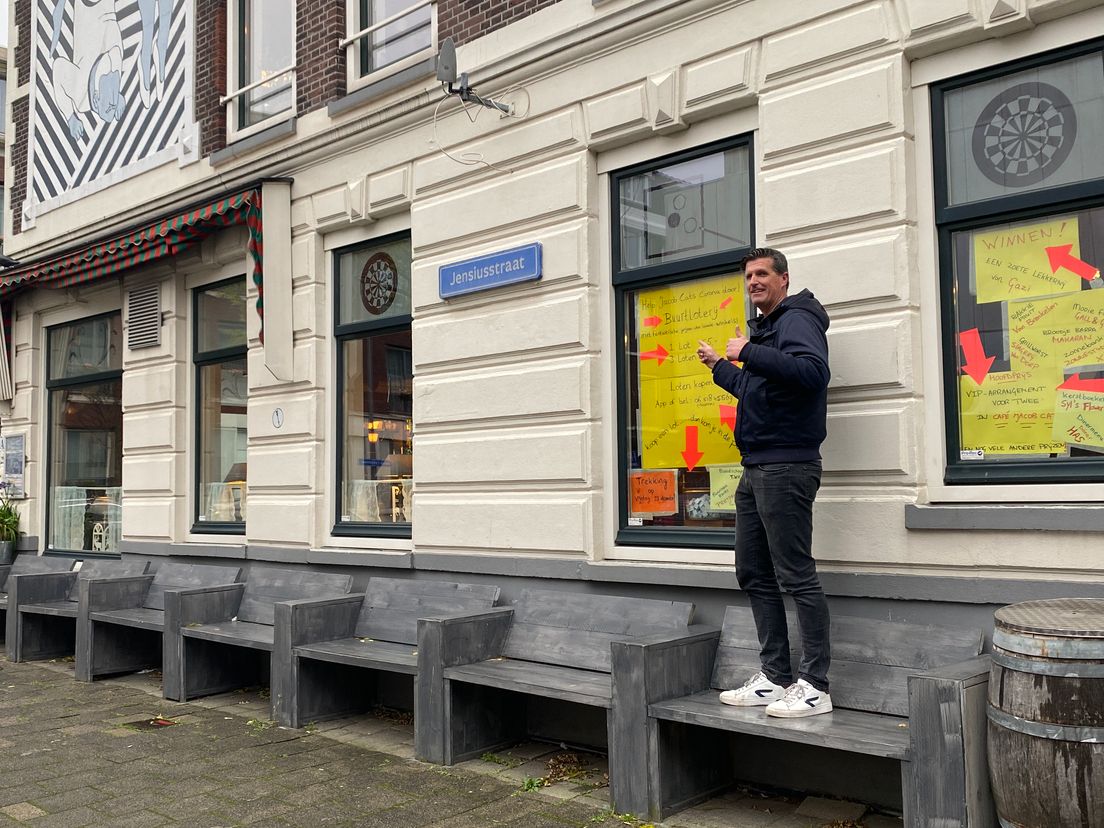 In het raam van café hangen de spelregels van de buurtloterij