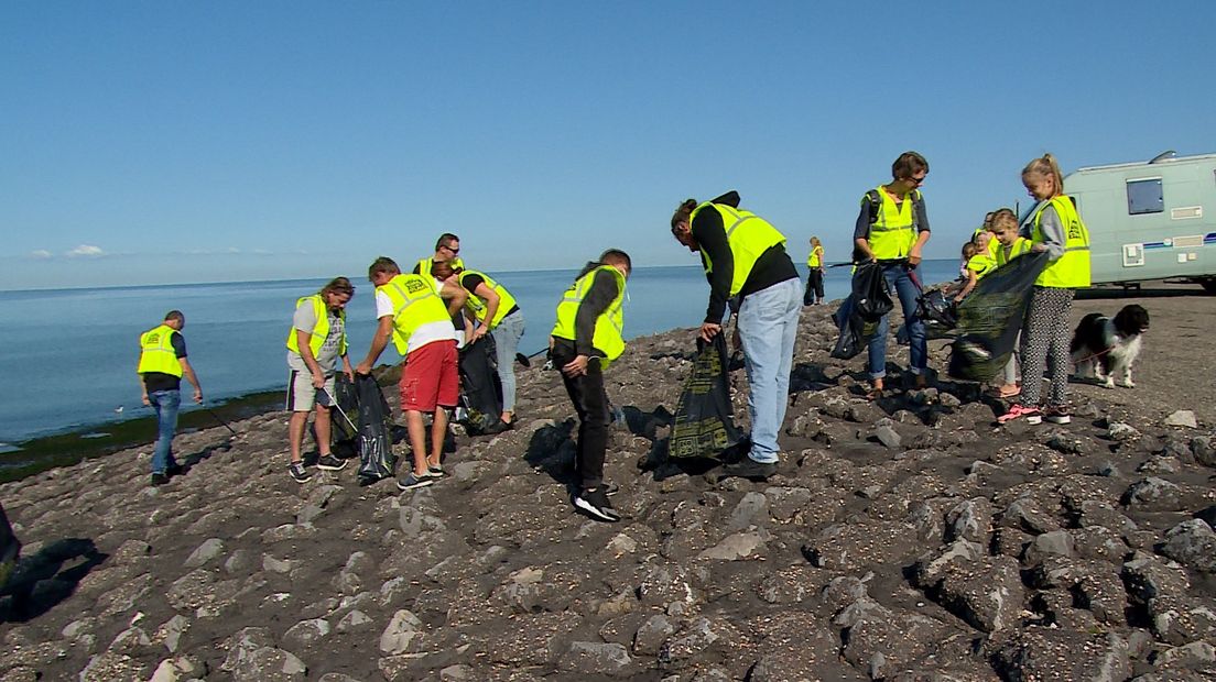 Bende van dertig op het strand van de Brouwersdam om puin te ruimen