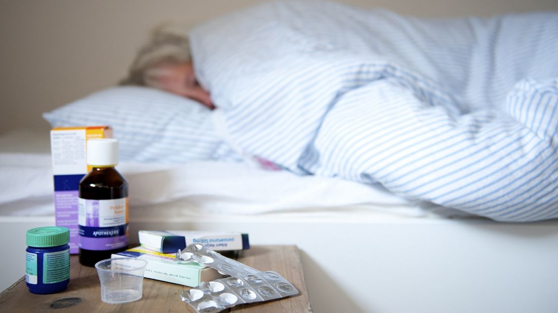 Een vrouw op bed met griep