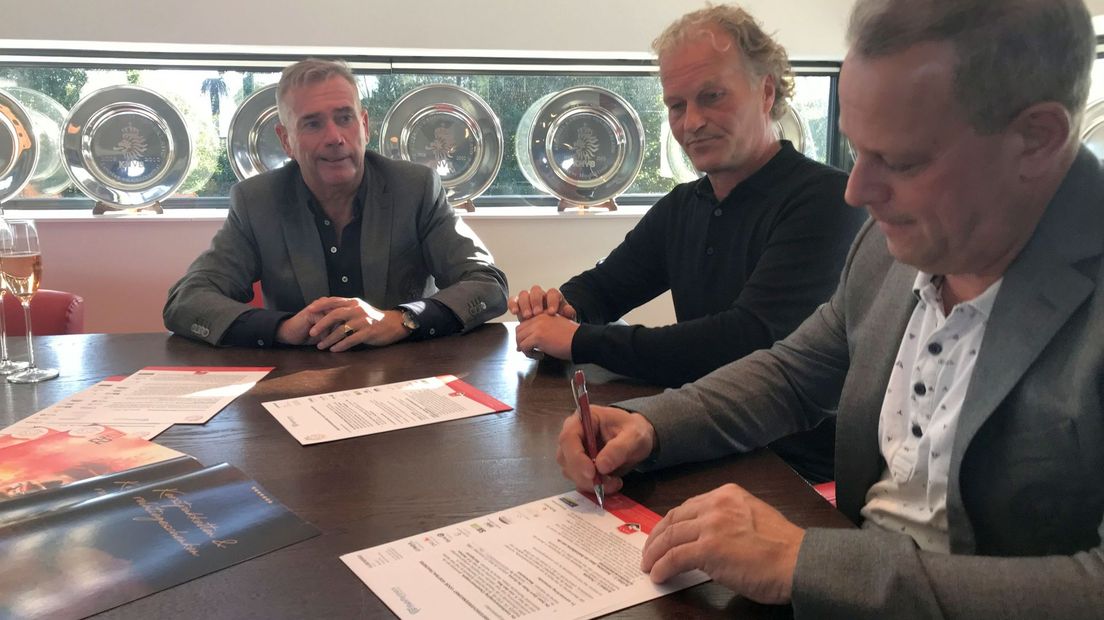 In het midden De Gunst bij de ondertekening van zijn contract.