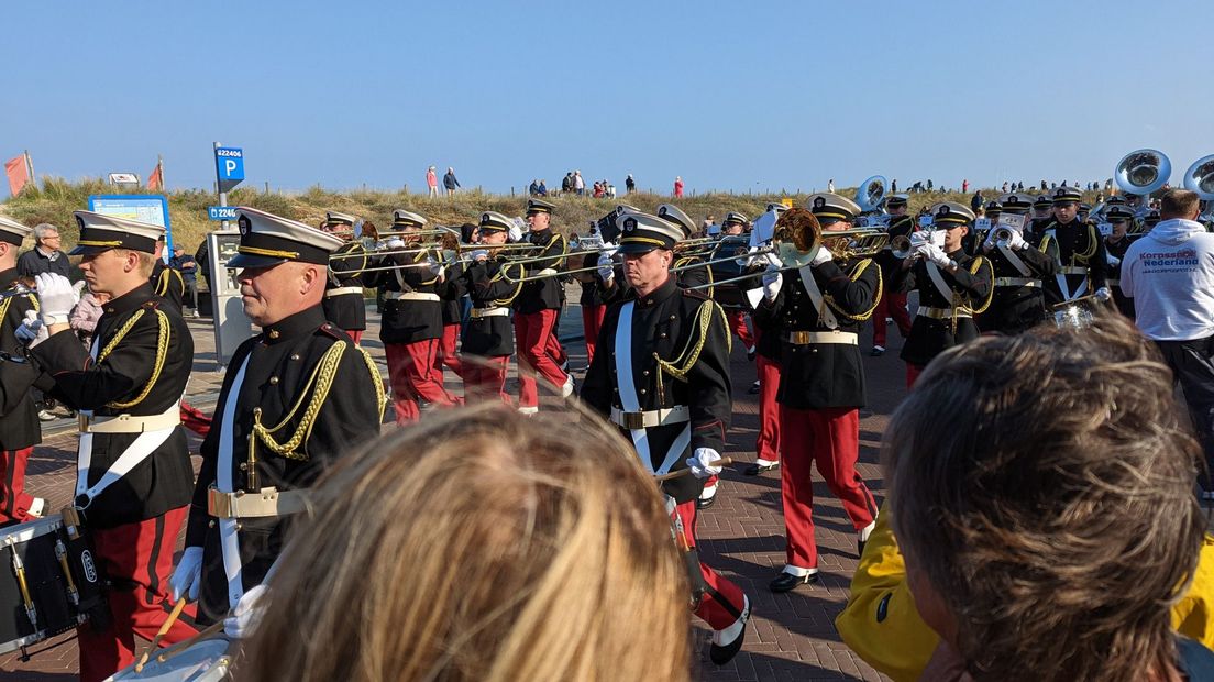 Publiek luistert naar muziek van een muziekkorps tijdens het Bloemencorso.