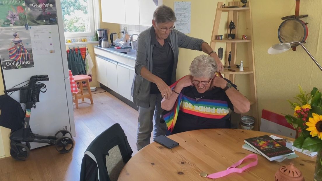 Mien Kluiters doet Magda Römgens de Mrs. Pride Senior vlag om