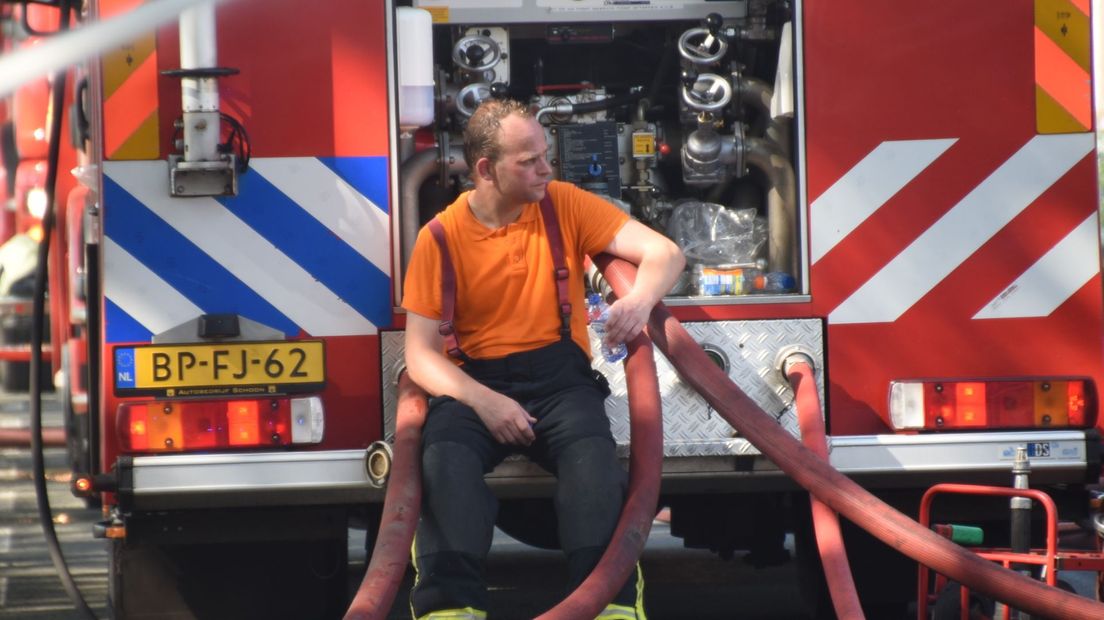 Een brandweerman puft uit nadat de brand is geblust