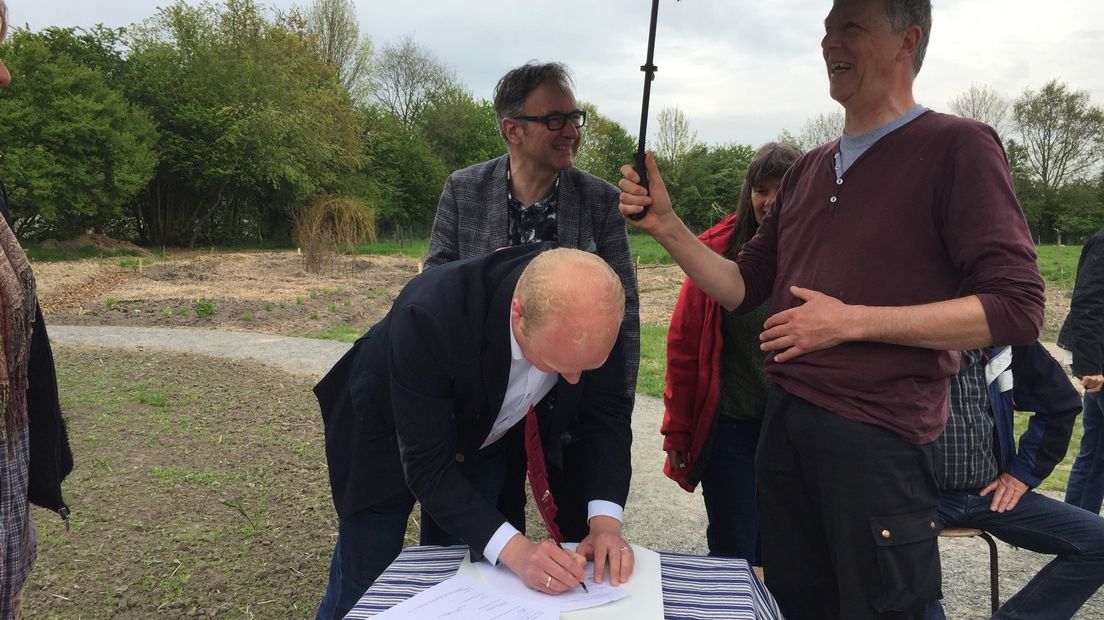 Wethouder Harmannus Blok tekent voor de overdacht van de grond.