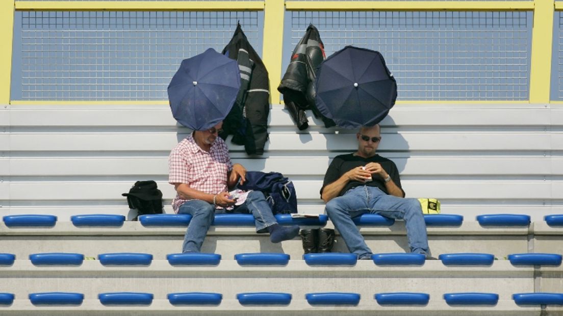 In 2005 beschermen bezoekers zich tegen de zon (Rechten: ANP/Vincent Jannink)