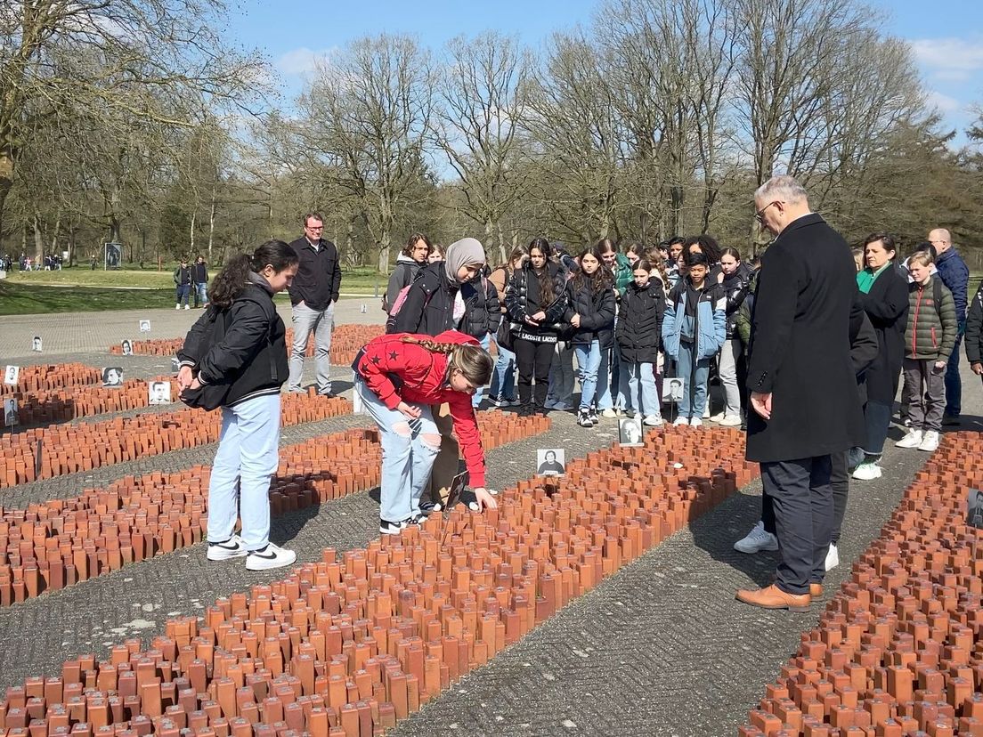 Leerlingen leggen steentjes bij het monument 'De 102.000 stenen'
