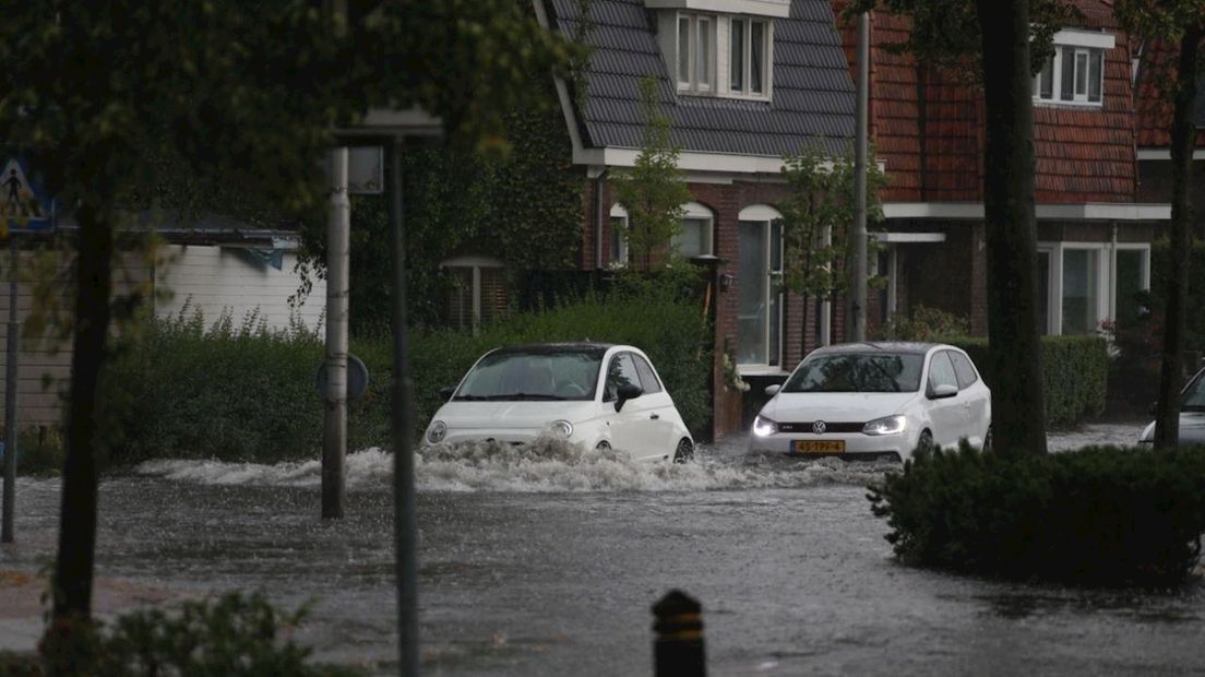 Auto's rijden kniediep door het water in Overdinkel