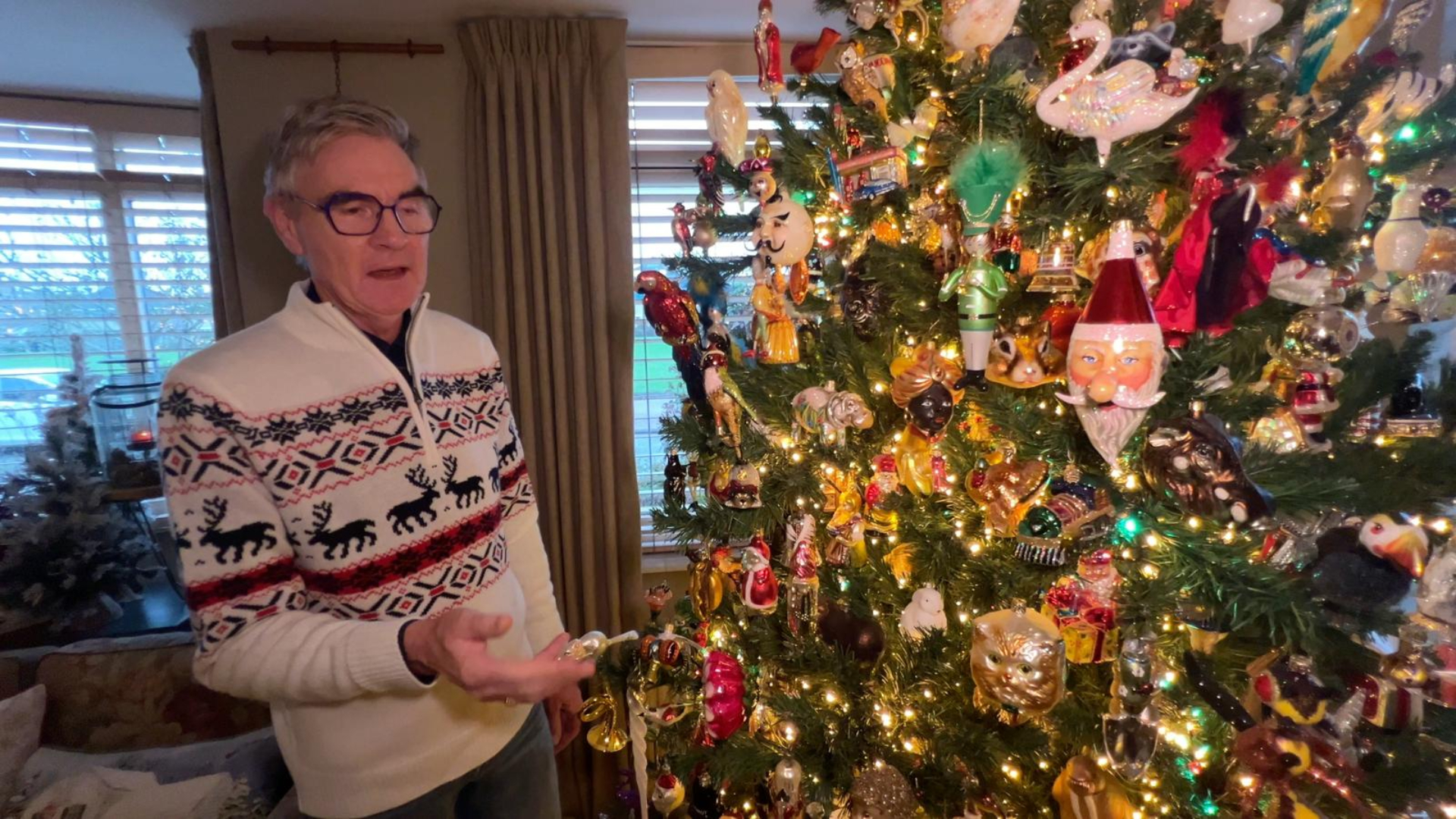 René bij een van zijn drukversierde kerstbomen.