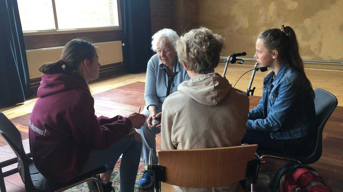Spelers van theatergroep Woest Oost in gesprek met ouderen.