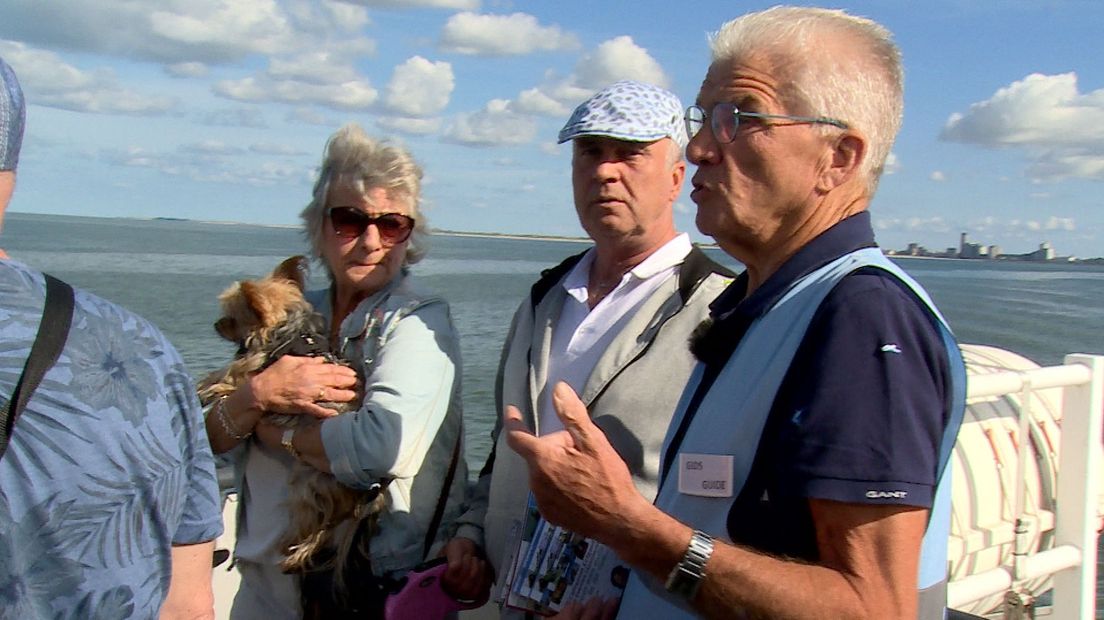 Gids Jaap Albregste vertelt aan boord van de Westerscheldeferry