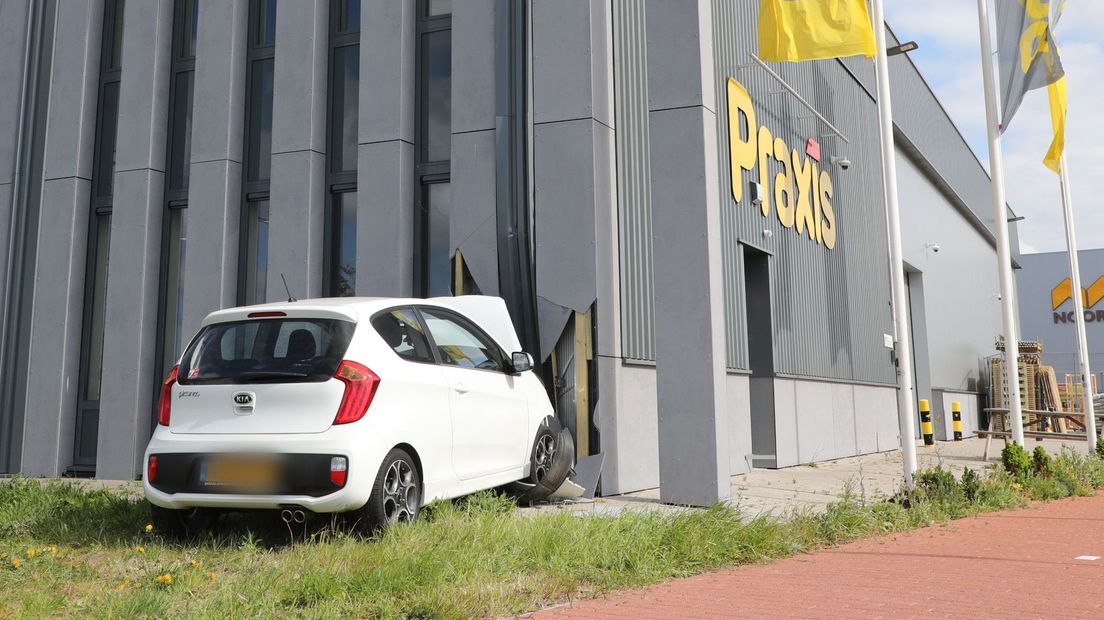 De auto botste tegen het pand na een aanrijding met een andere auto op de kruising