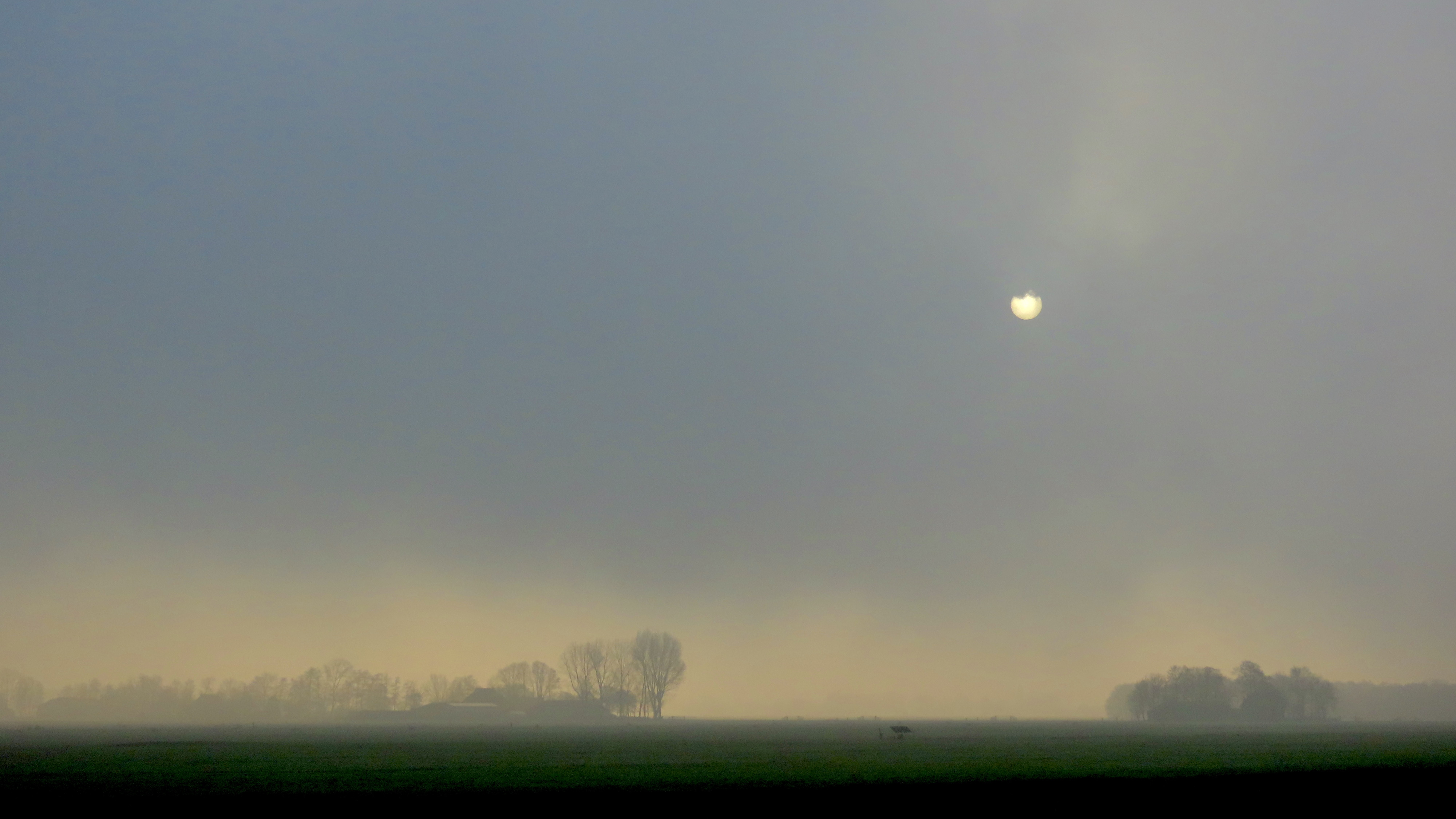 De sinne besiket troch de mist hinne te kommen by de Smelle Ie