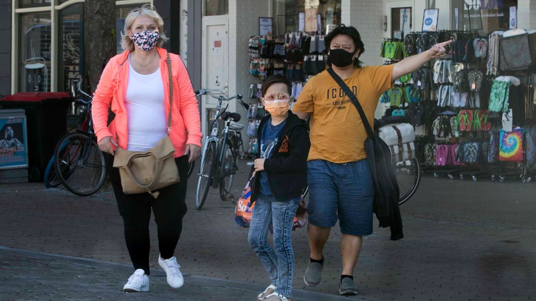 Een gezin draagt mondkapjes