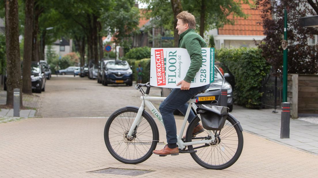 Een makelaar fietst door Baarn, op weg naar een verkochte woning.