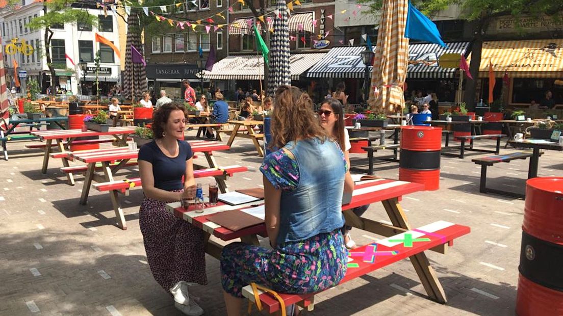 Drie vrouwen houden zich netjes aan de coronamaatregelen op de Grote Markt in Den Haag