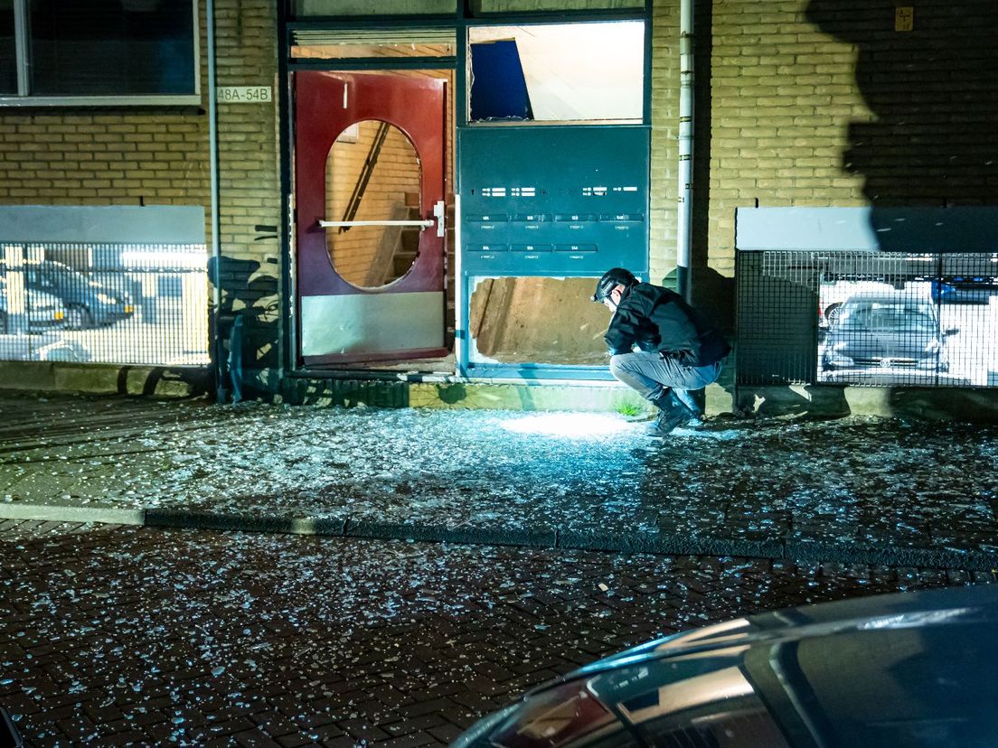 Veel glassplinters in de Rotterdamse Van Speykstraat na de aanslag een dag eerder in het portiek