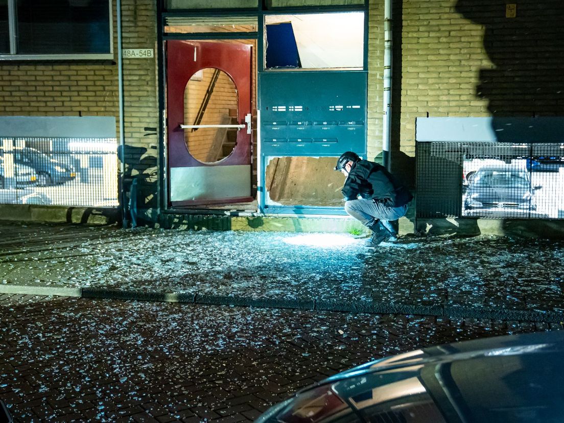 Veel glassplinters in de Rotterdamse Van Speykstraat na de aanslag een dag eerder  in het portiek