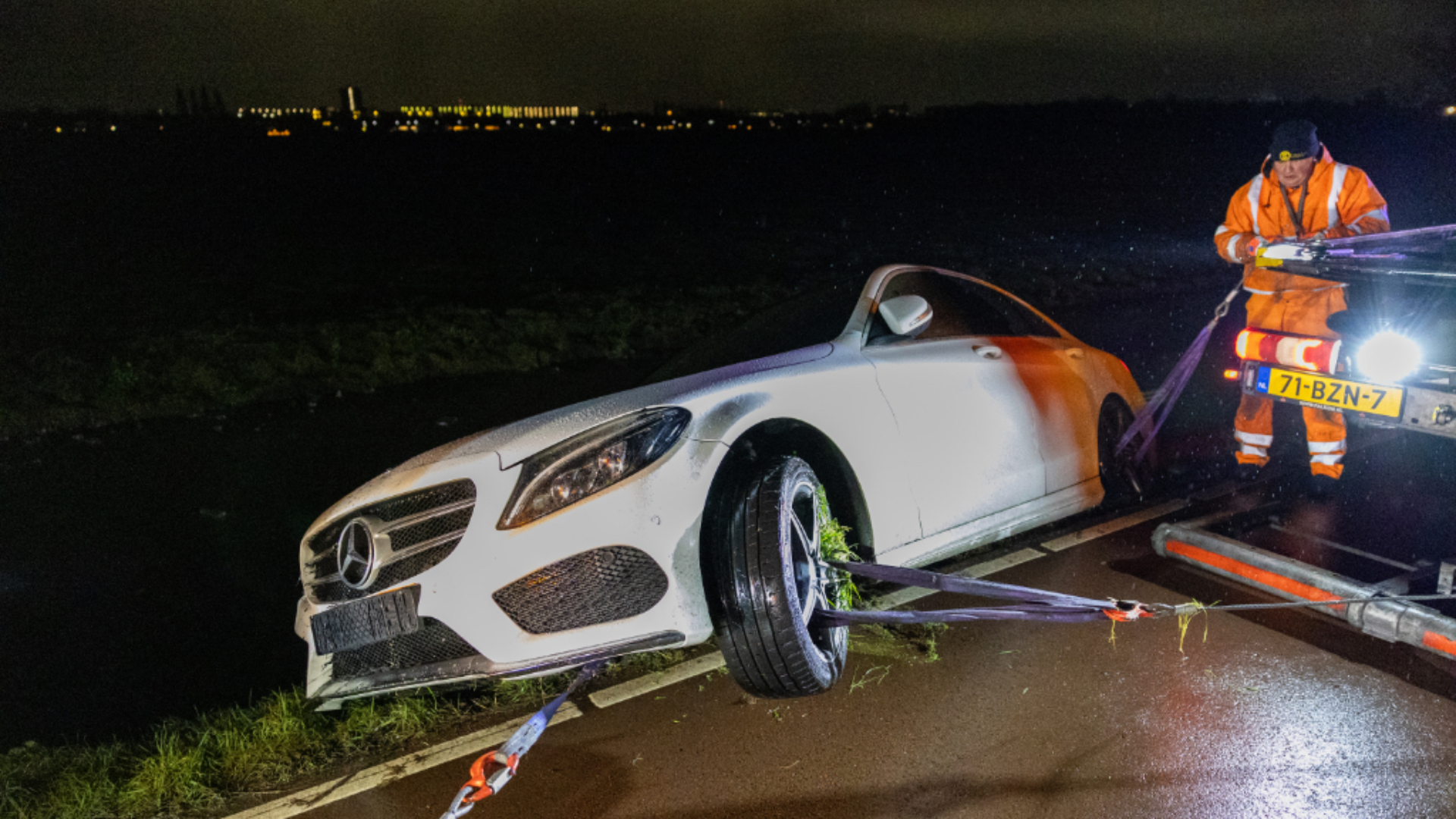Auto te water aan de Woudweg in Schiedam vanwege gladheid