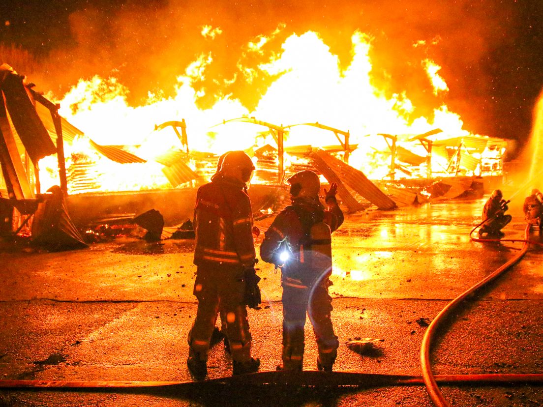 De brandweer probeert met man en macht de brand aan de Molendijk in Zuidland te blussen