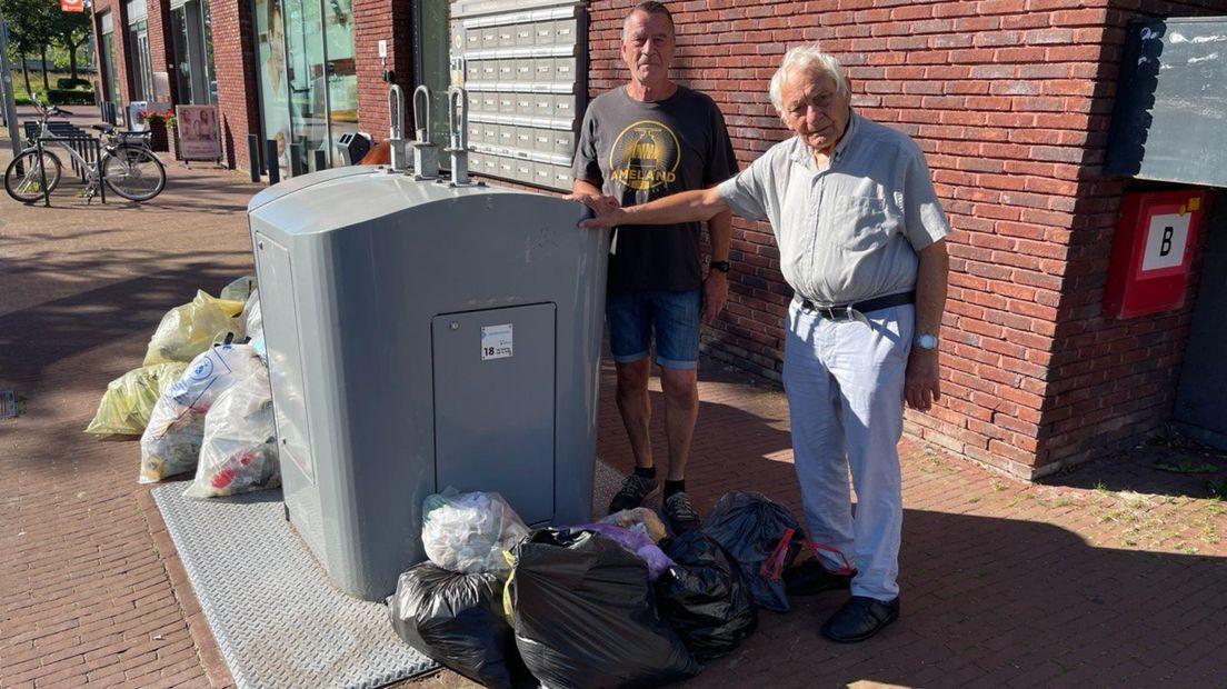 Hans Pinkster (l) en Bertus Datema bij de afvalcontainer