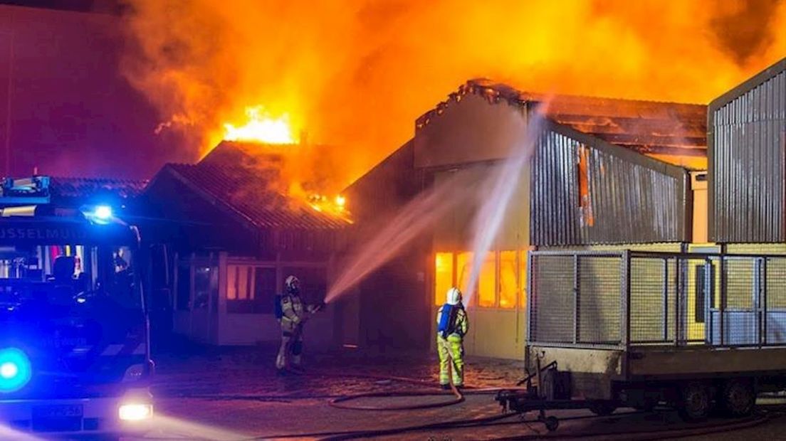 De brandweer probeert de brand in de loods onder controle te krijgen