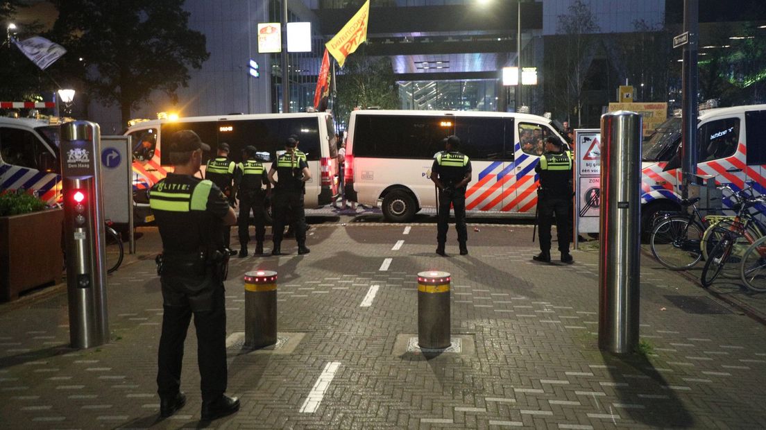 De politie houdt demonstranten uit de buurt van de persconferentie