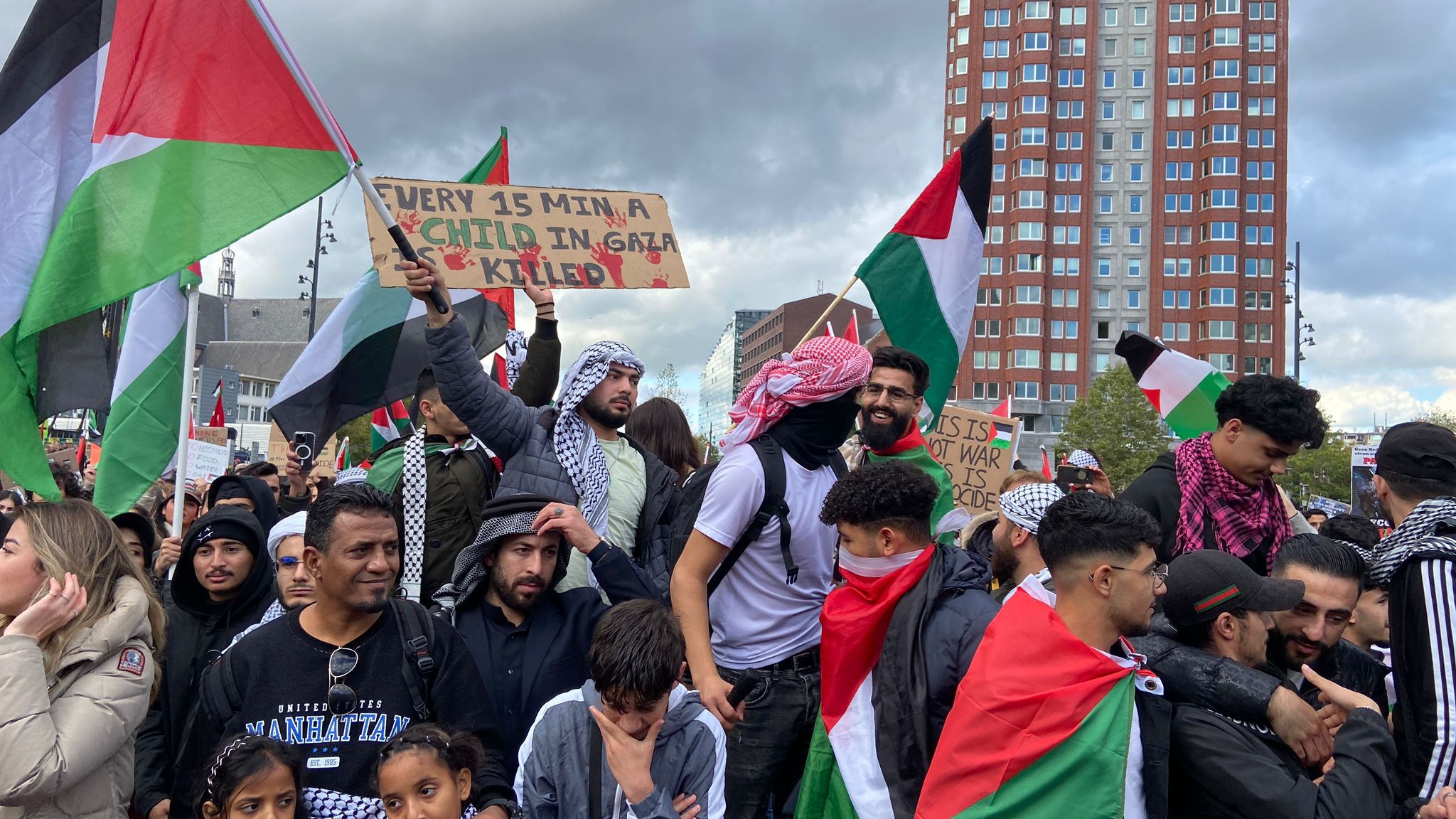 Demonstranten met een bord waarop staat: "elke 15 minuten wordt een kind vermoord in Gaza"
