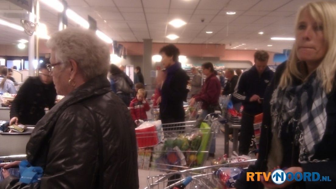 Lange rijen voor de kassa van een supermarkt in de Groninger wijk Vinkhuizen