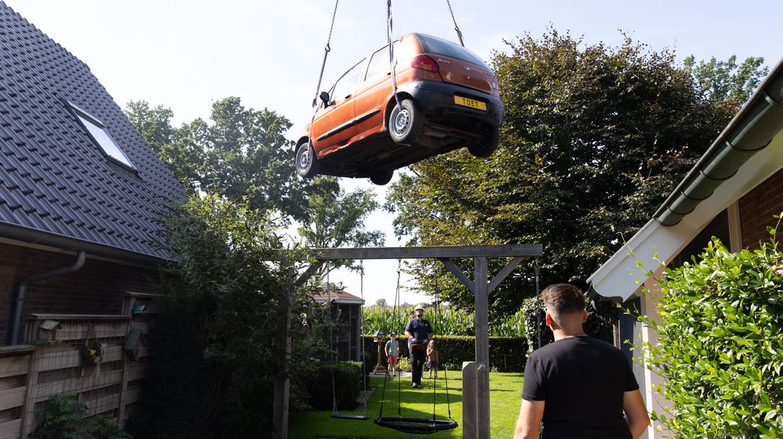 De auto wordt getild naar de achtertuin