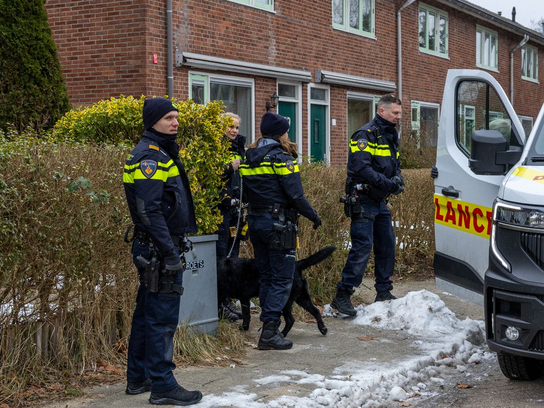 Politie draagt hond verdachte over aan dierenambulance.