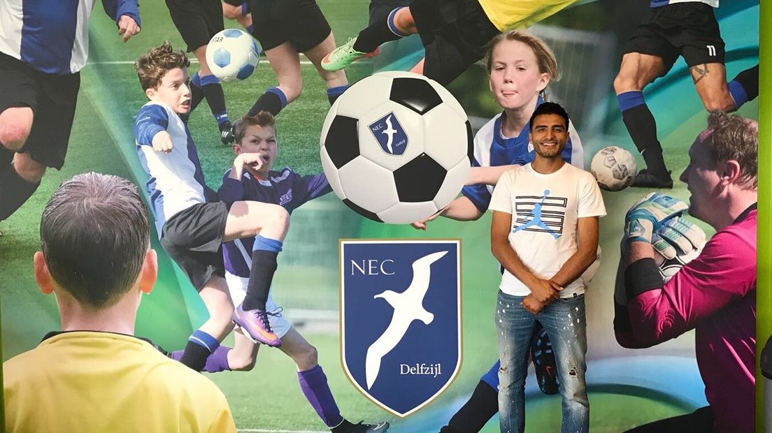 Soufiane Touzani poseert voor het clublogo van NEC Delfzijl