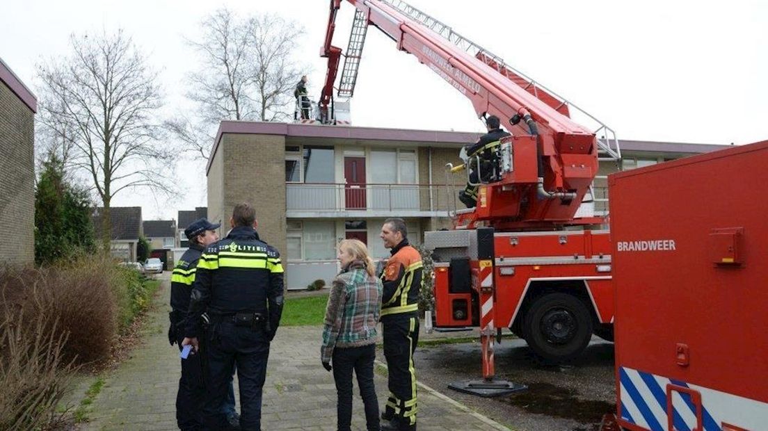Met een hoogwerker wordt op het dak van de woning gezocht