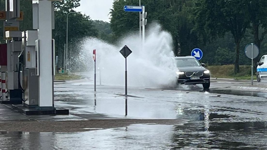Een auto in Herkenbosch rijdt door een fikse plas water.