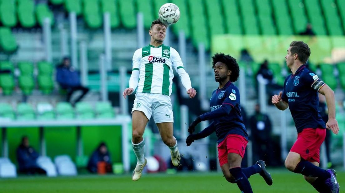 Joël van Kaam wint een kopduel namens FC Groningen; Nelom en Peters kijken toe
