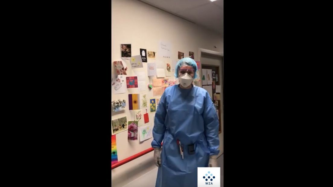 Voor een muur vol kaartjes, doet een van de verpleegkundigen het woord (Rechten: Screenshot WZA-video)