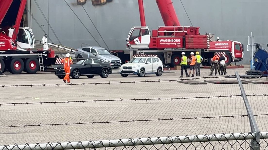 Auto's uit het rampschip worden op de kade gezet