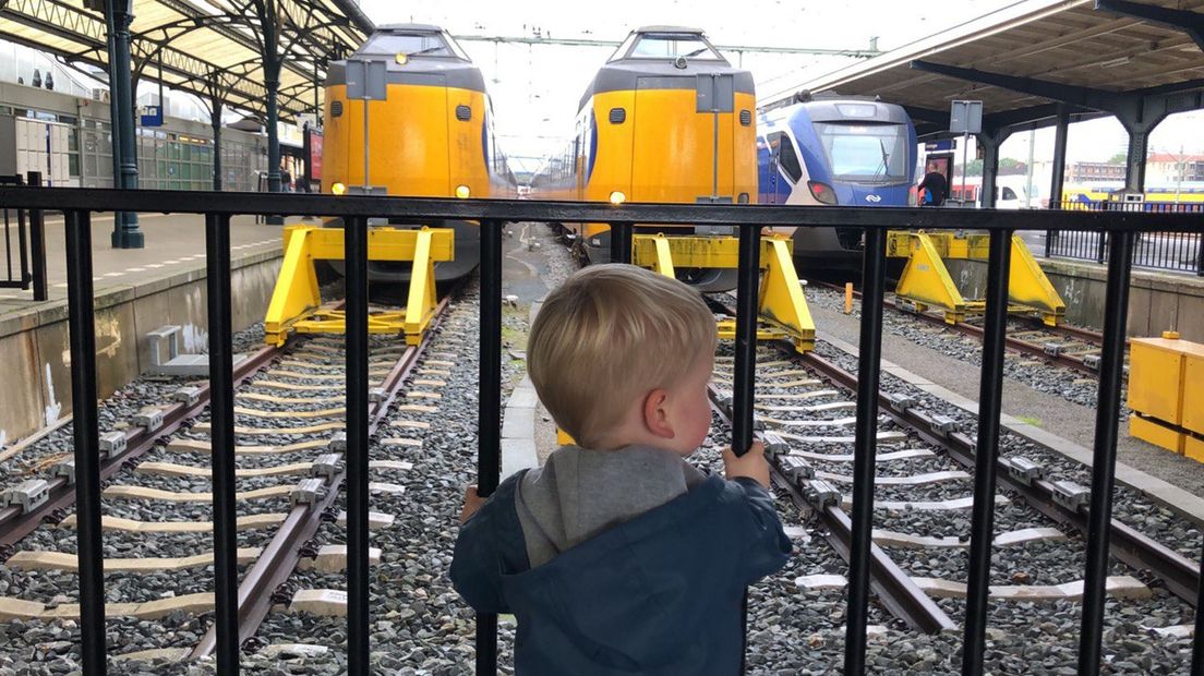 Een jonge liefhebber van het OV bewondert treinen