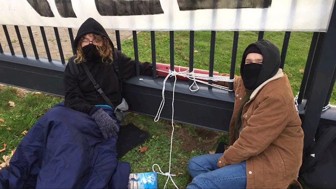 Twee actievoerders bonden zich vast aan het hek bij Thales
