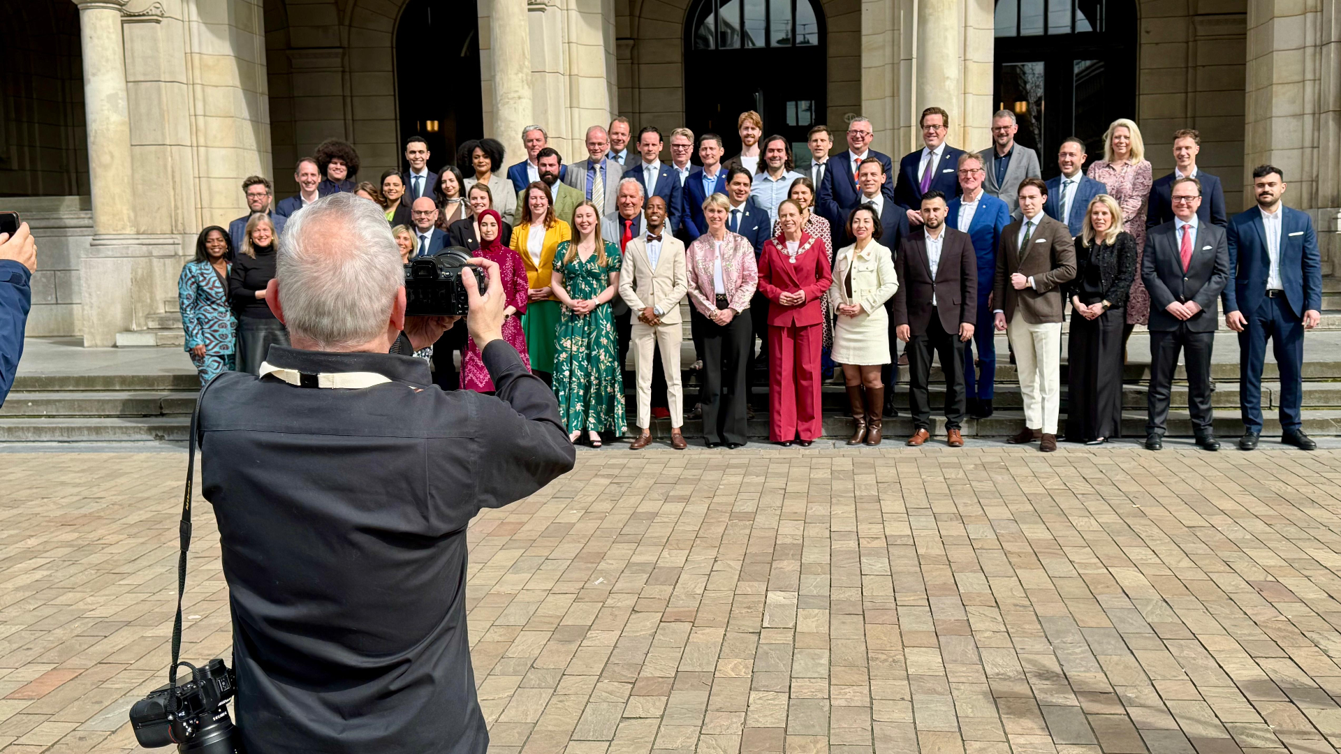 De nieuwe gemeenteraad gaat na de installatie op de foto voor het stadhuis.