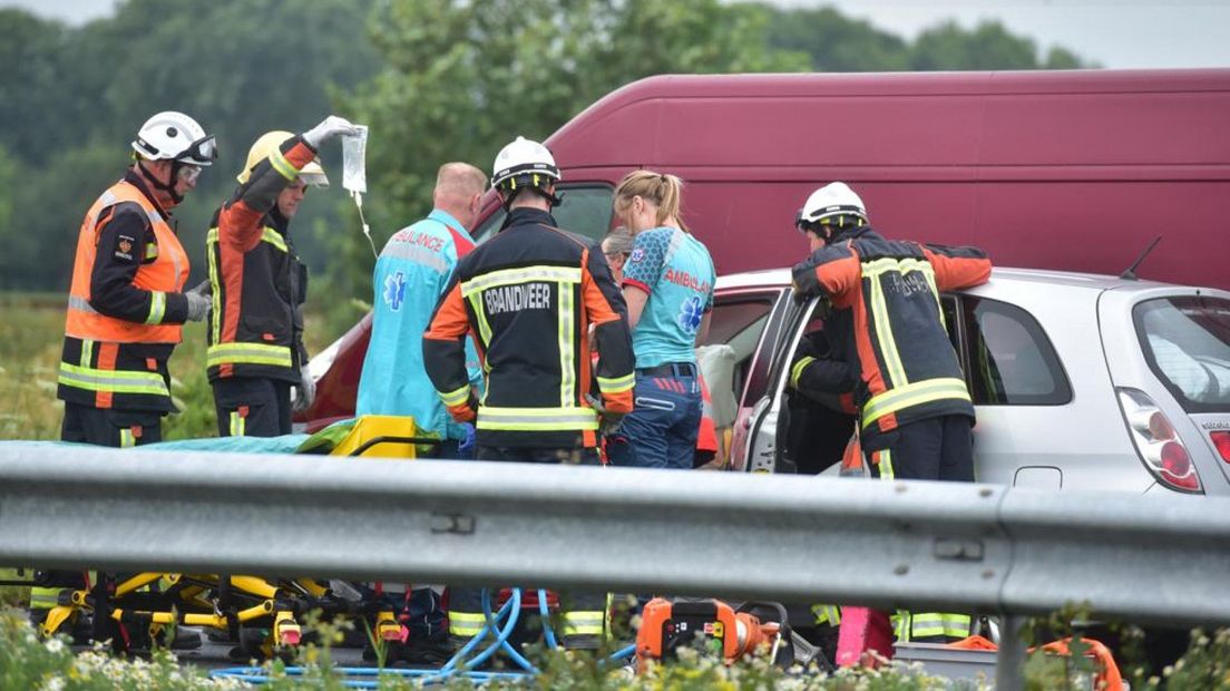Hulpverleners proberen de automobilst te bevrijden