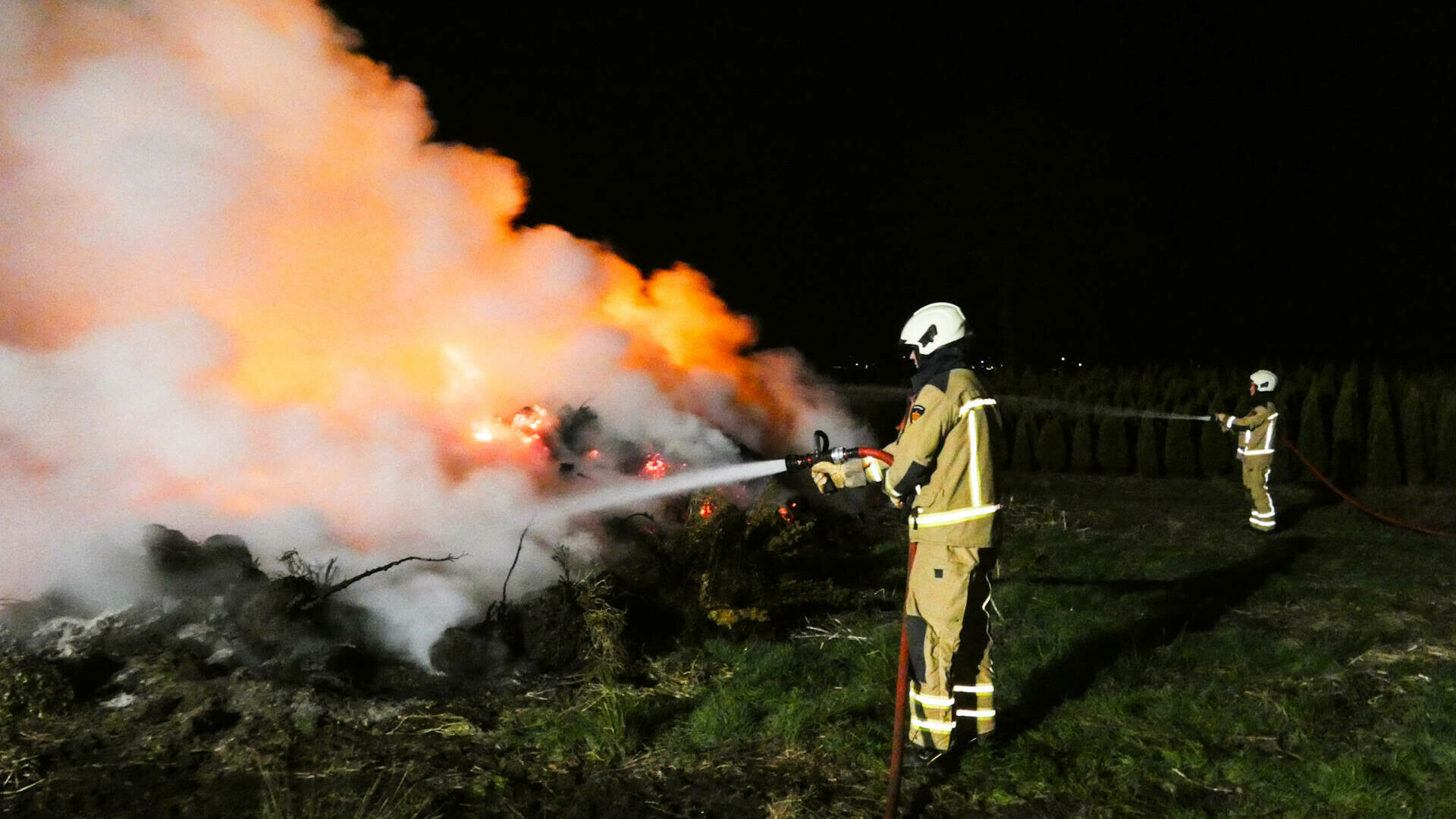 Stapel coniferen in brand in Hoogersmilde